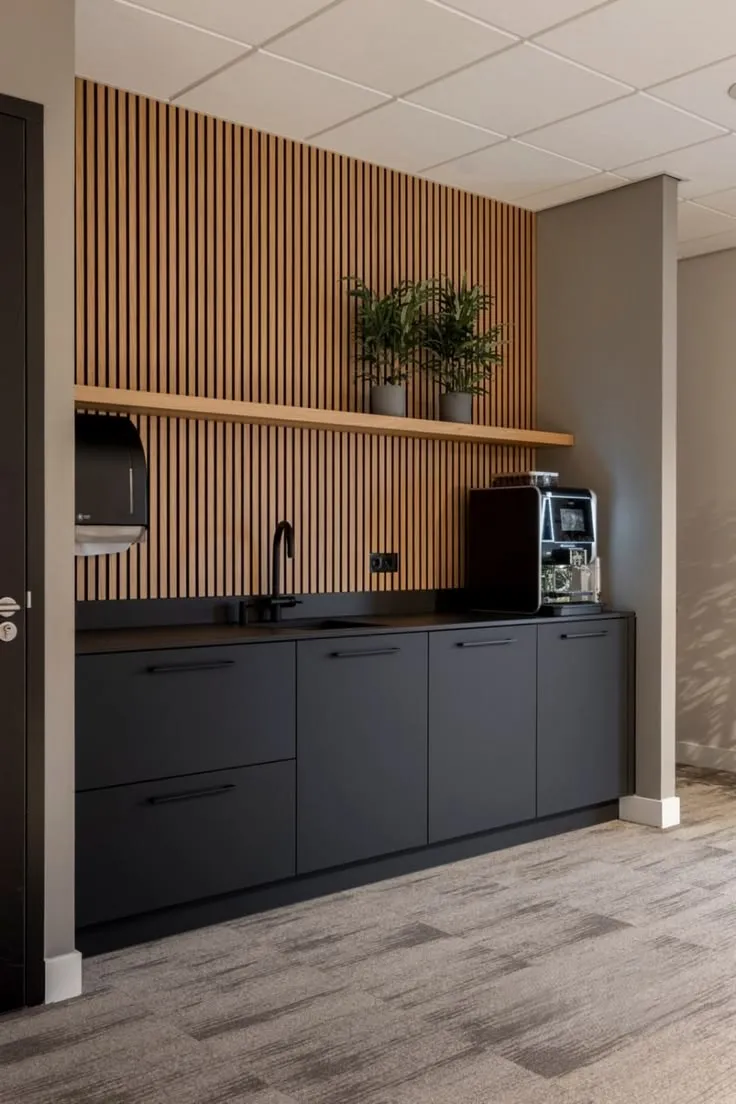 Cucina attrezzata per area break con pannelli in legno e macchina da caffè