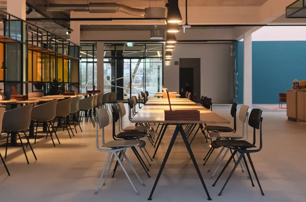 Break area with long tables in an open-space office